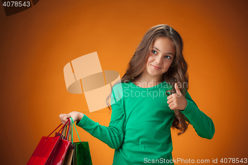 Image of The cute cheerful little girl with shopping bags