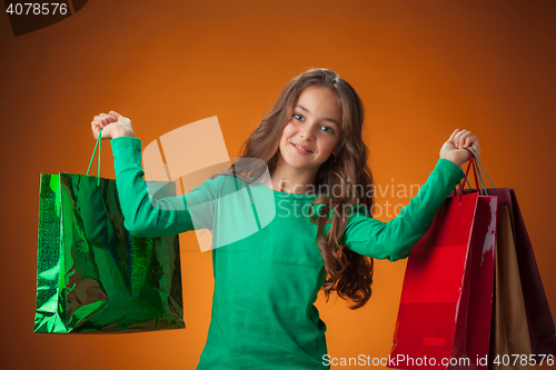 Image of The cute cheerful little girl with shopping bags