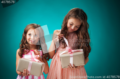 Image of The two cute cheerful little girls on blue background
