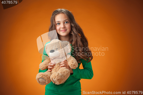 Image of The cute cheerful little girl on orange background