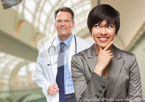 Image of Male Doctor Stands Behind Woman Looking To Side Inside Hospital