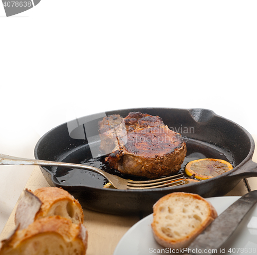 Image of pork chop seared on iron skillet