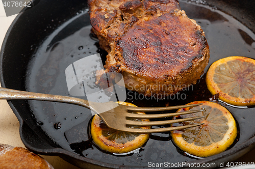 Image of pork chop seared on iron skillet