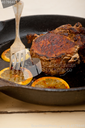 Image of pork chop seared on iron skillet