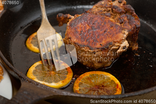 Image of pork chop seared on iron skillet