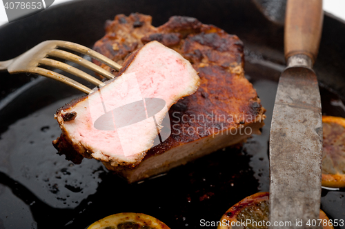 Image of pork chop seared on iron skillet