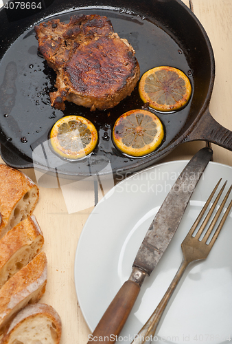Image of pork chop seared on iron skillet