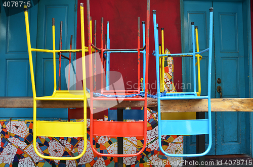 Image of Colorful chairs on a wooden table