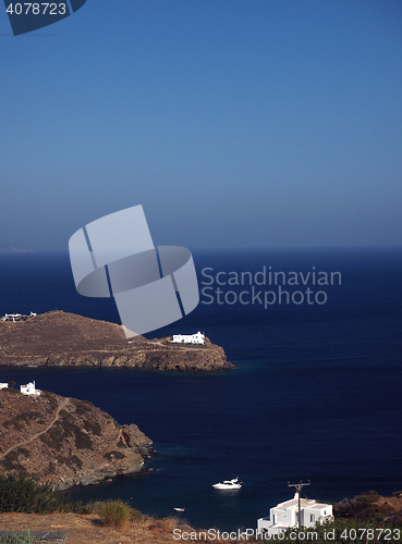 Image of church monastery on promontory in Aegean Sea with houses and boa