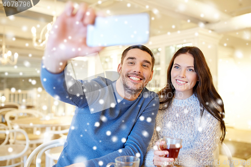 Image of couple taking smartphone selfie at cafe restaurant