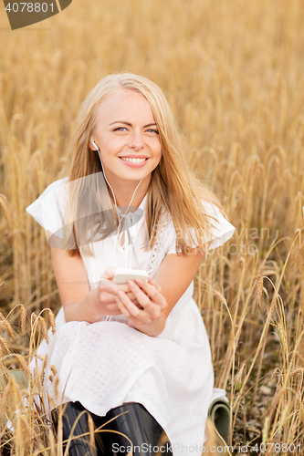 Image of happy woman with smartphone and earphones