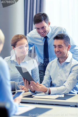 Image of smiling business people with tablet pc in office