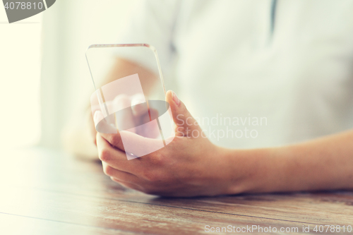 Image of close up of woman with transparent smartphone