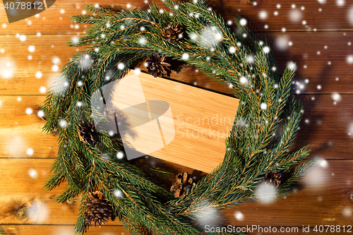 Image of natural green fir branch wreath and wooden board