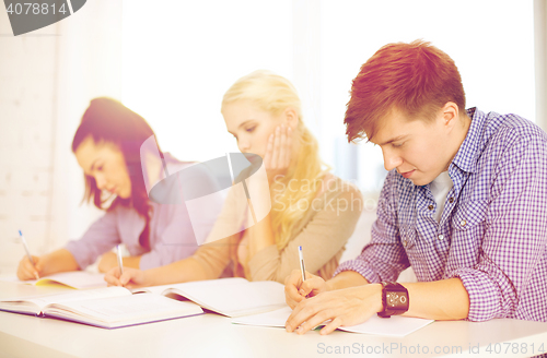 Image of tired students with notebooks at school