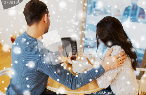 Image of happy couple with tablet pc drinking tea at cafe