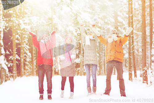 Image of group of happy friends playin with snow in forest