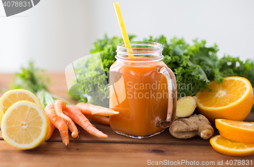 Image of glass jug of carrot juice, fruits and vegetables