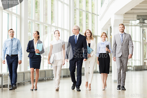 Image of business people walking along office building