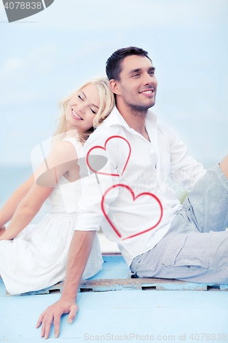 Image of couple sitting on boat at sea side