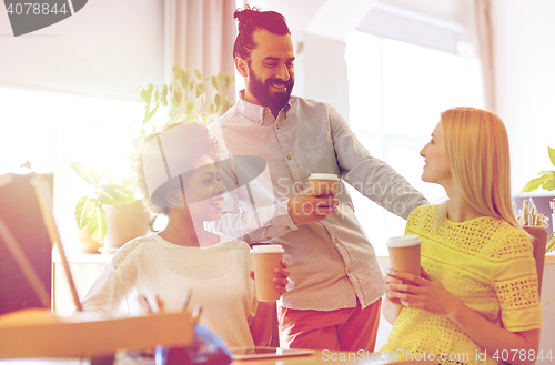 Image of happy creative team drinking coffee in office