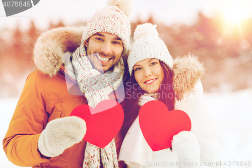 Image of happy couple with red hearts over winter landscape