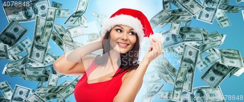Image of beautiful sexy woman in santa hat over money rain
