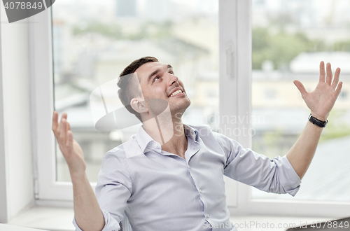 Image of happy businessman with laptop in office