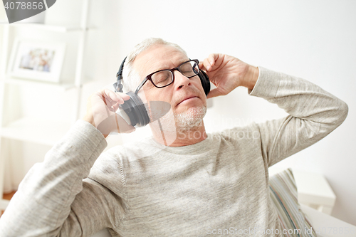 Image of happy man in headphones listening to music at home