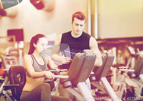 Image of woman with trainer on exercise bike in gym