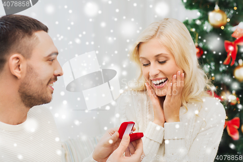 Image of man giving woman engagement ring for christmas