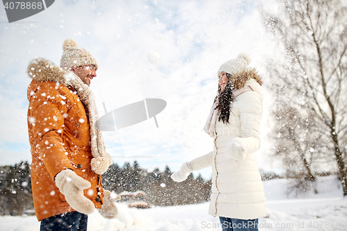 Image of happy couple playing with snow in winter