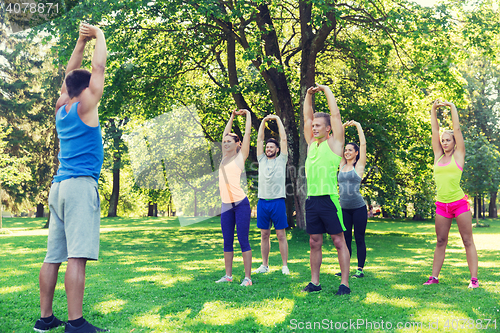 Image of group of friends or sportsmen exercising outdoors