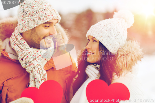 Image of happy couple with red hearts over winter landscape