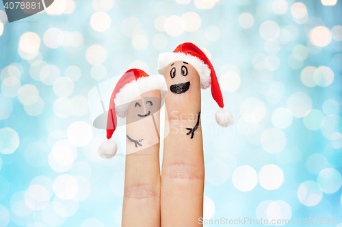 Image of close up of two fingers with smiley and santa hats
