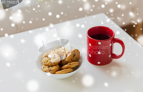 Image of close up of oat cookies and red tea cup on table