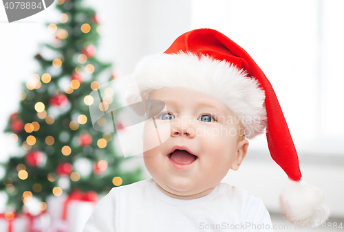 Image of baby boy in christmas santa hat over blue lights
