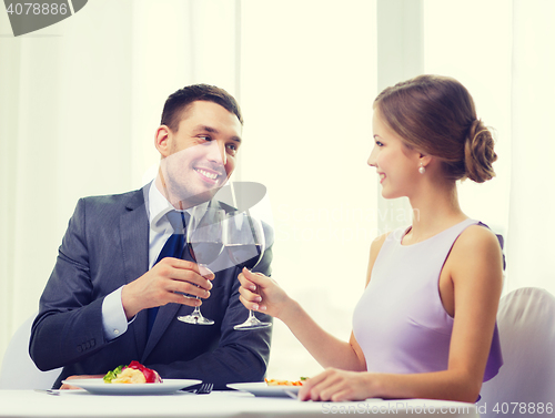 Image of couple with main course and red wine at restaurant