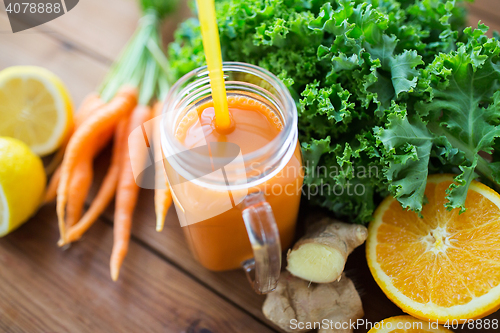 Image of glass jug of carrot juice, fruits and vegetables