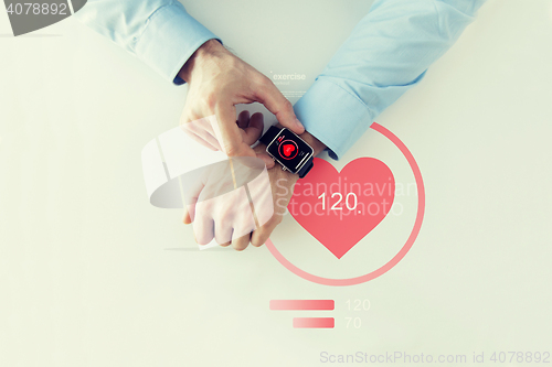 Image of close up of hands with heart icon on smart watch