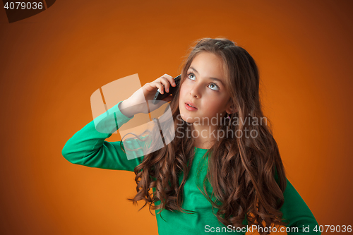 Image of The cute cheerful little girl on orange background