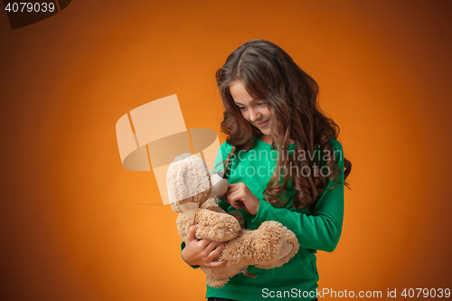 Image of The cute cheerful little girl on orange background