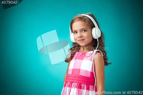 Image of The cute cheerful little girl on orange background