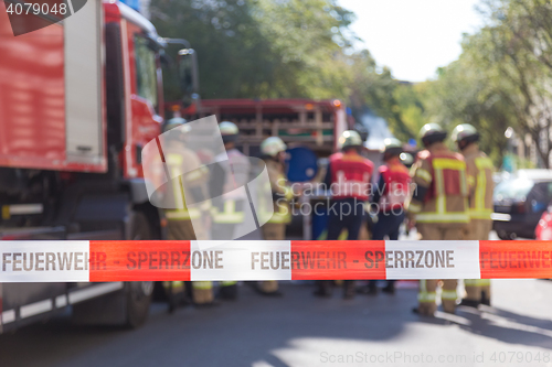 Image of Team of firefighters by firetruck on accident location.