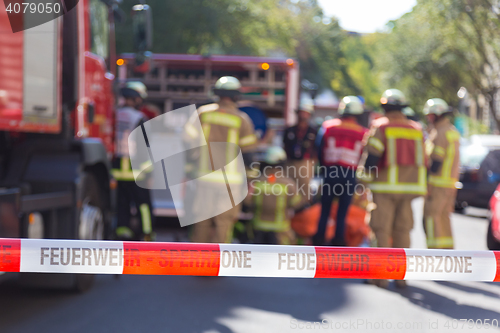 Image of Team of firefighters by firetruck on accident location.