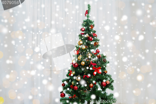 Image of christmas tree in living room over window curtain