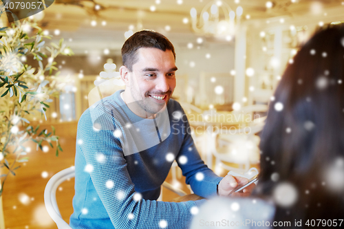 Image of happy couple talking at cafe or restaurant