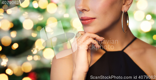 Image of close up of woman in black wearing diamond jewelry