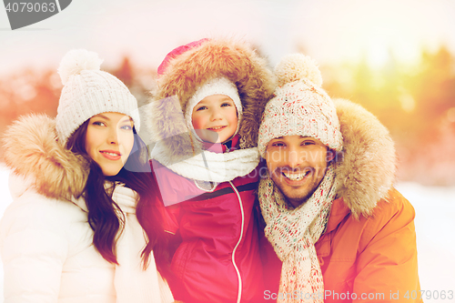 Image of happy family with child in winter clothes outdoors