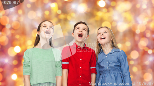 Image of amazed children looking up over holidays lights